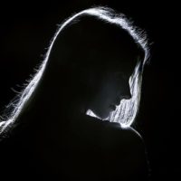 silhouette d'une jeune femme triste dans l'obscurité