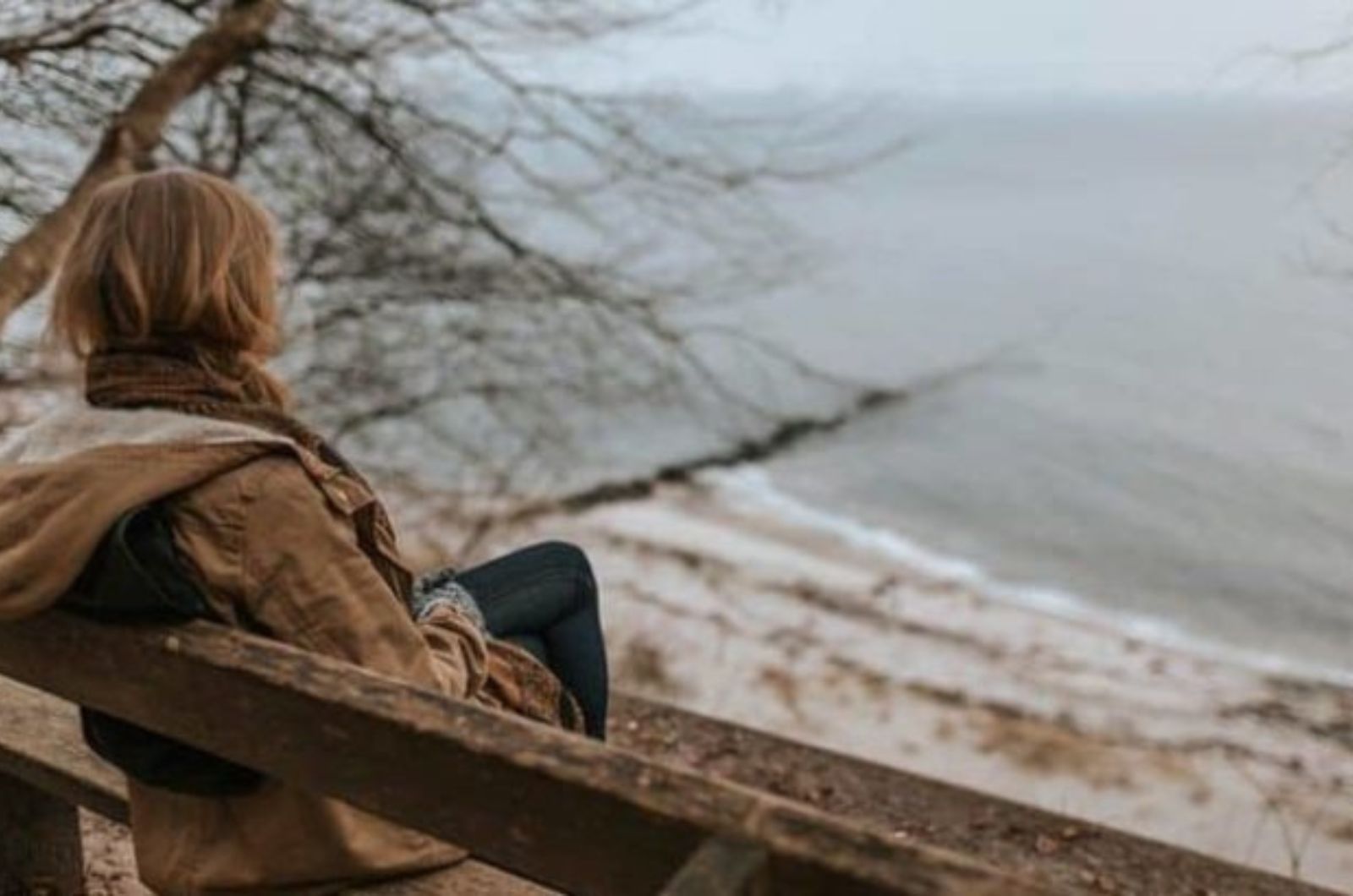 femme assise sur un banc au bord de locean