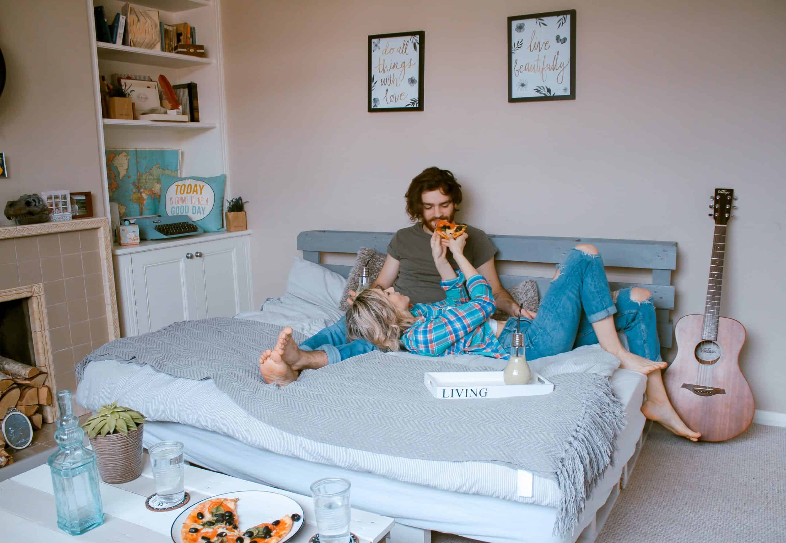 couple assis et manger sur le lit