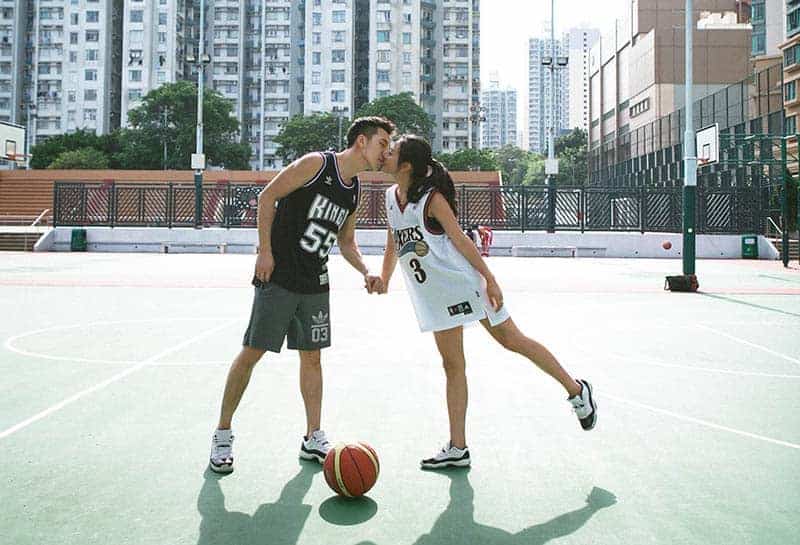 un homme et une femme s'embrassant en jouant au basket