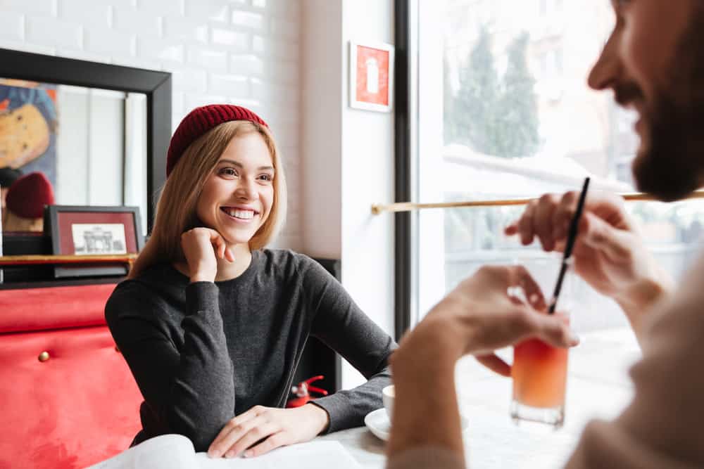 la femme et l'homme rient en s'asseyant