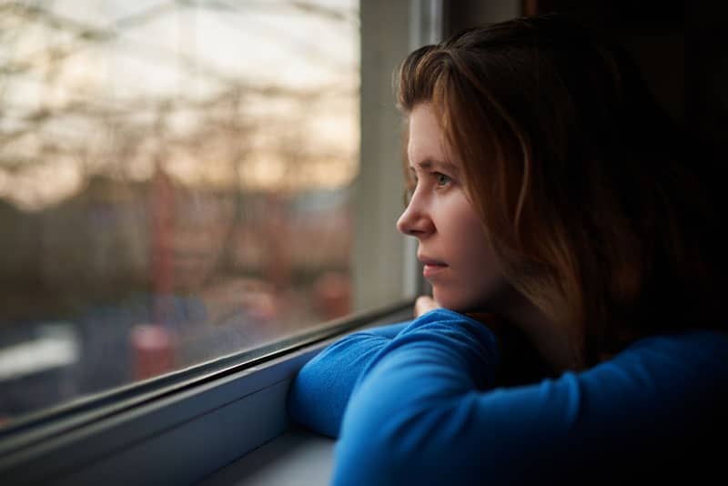 triste jeune femme par la fenêtre