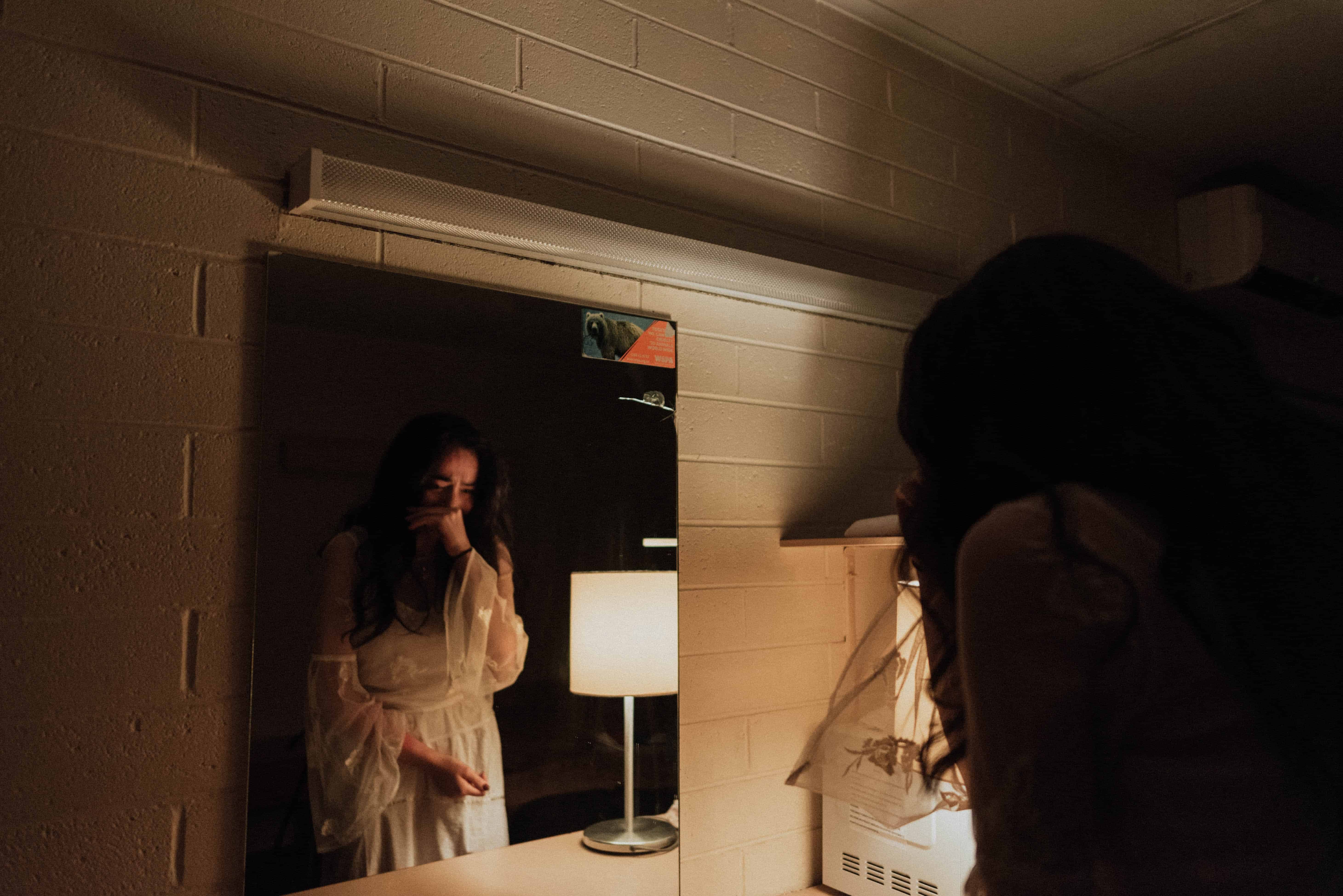 triste jeune femme se regardant dans le miroir et pleurant