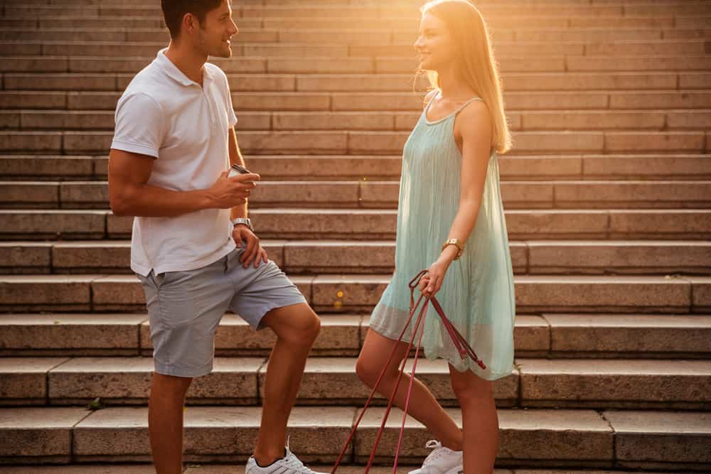 un homme et une femme se tiennent dans les escaliers et parlent