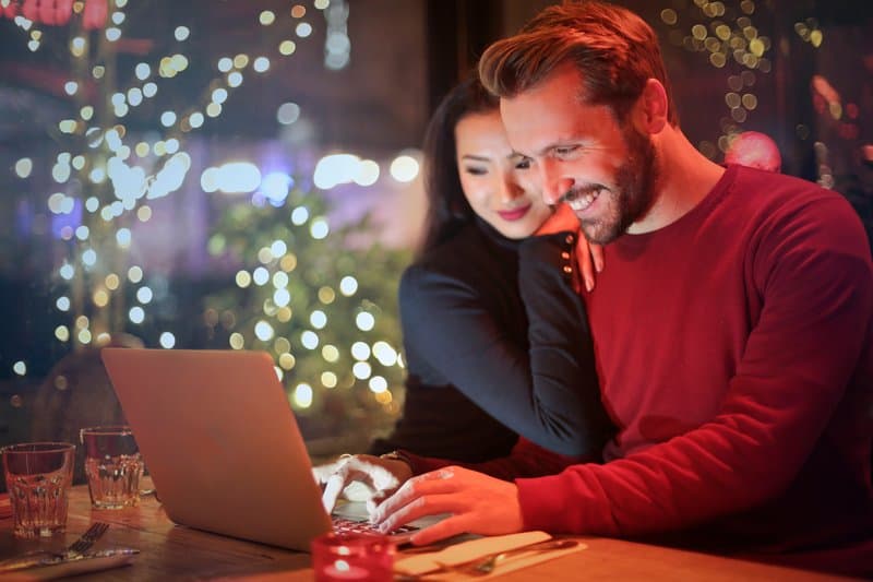 un homme et une femme sont assis derrière un ordinateur portable