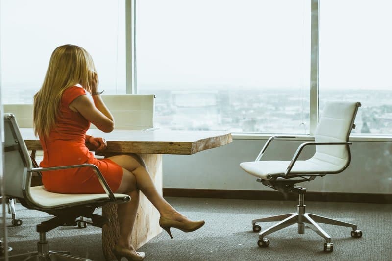 une femme blonde est assise à un bureau et passe un appel téléphonique