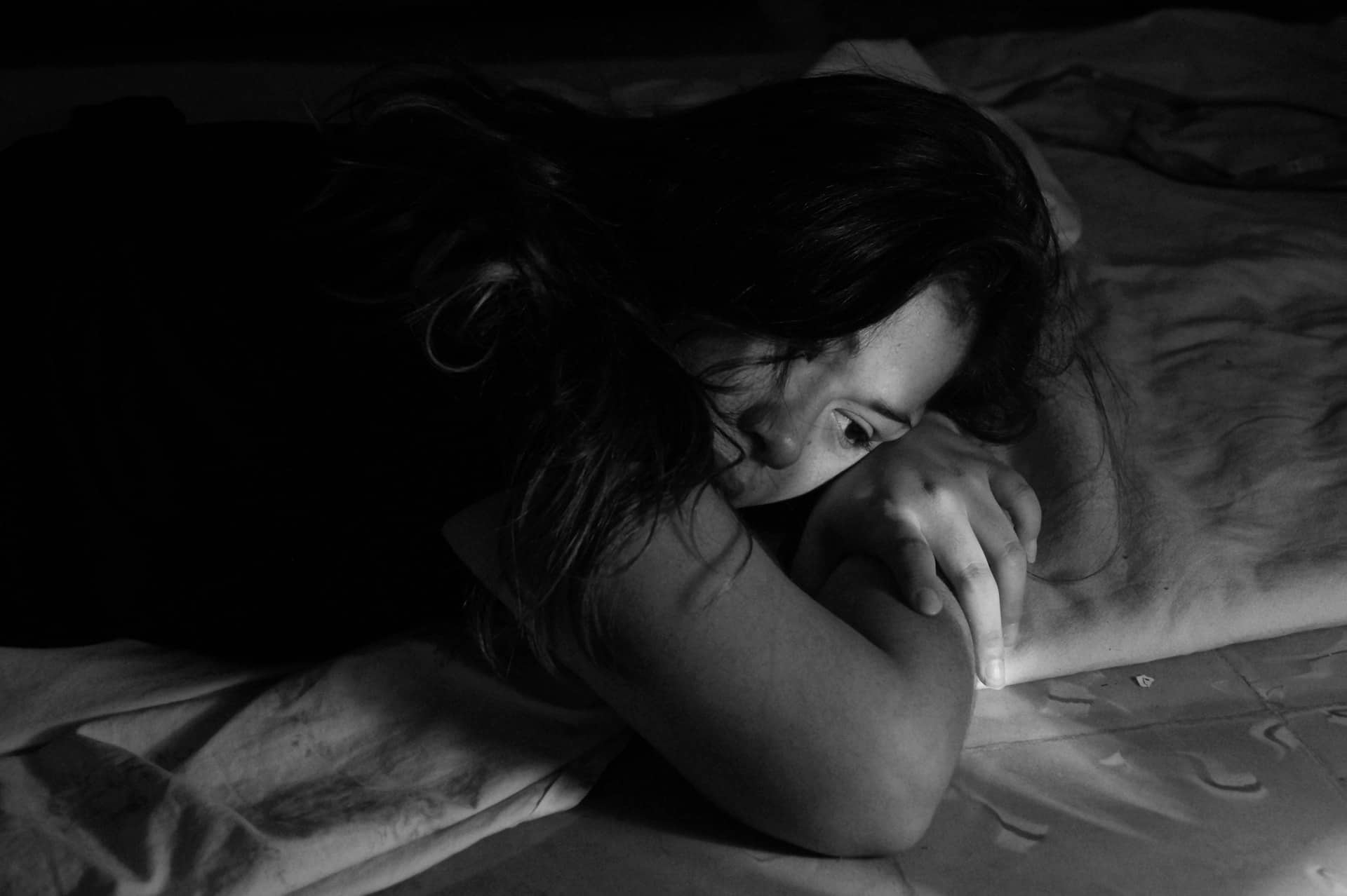 une femme triste allongée sur le lit