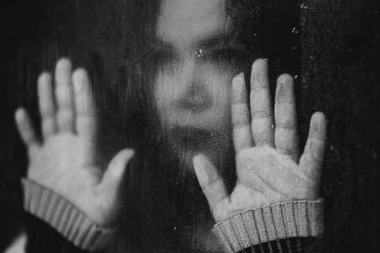une femme triste regarde par la fenêtre