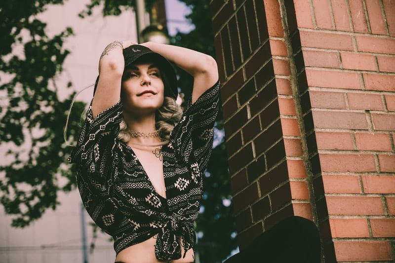 une femme à côté d'un mur de briques