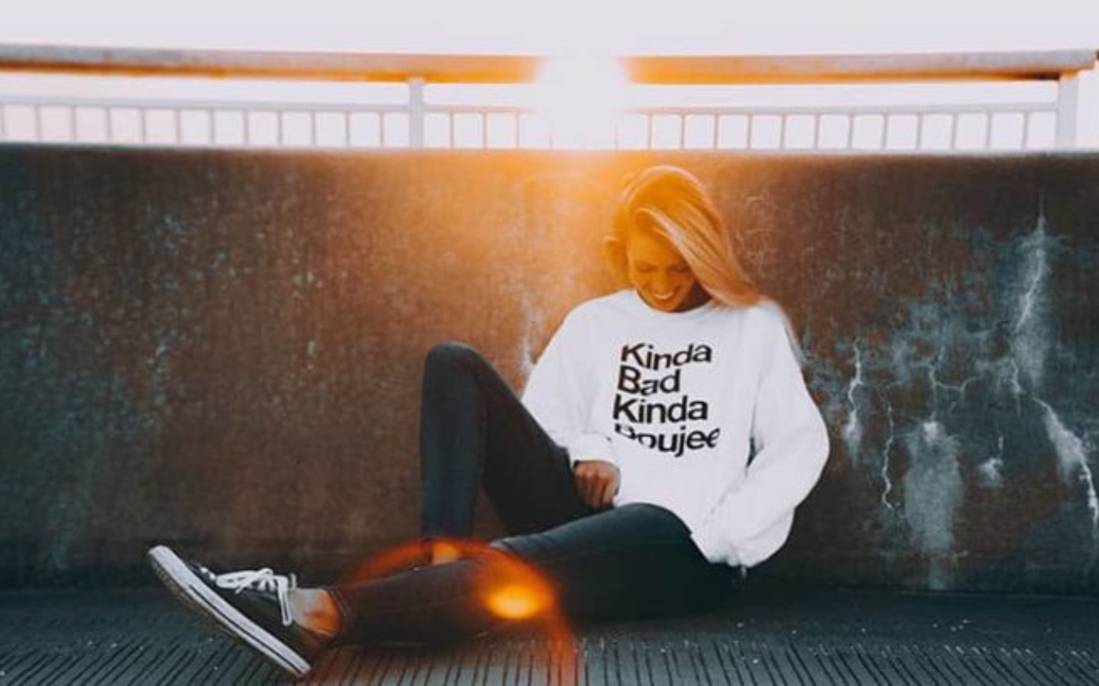jeune femme blonde assise au coucher du soleil