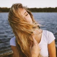 heureuse jeune femme blonde appréciant le vent