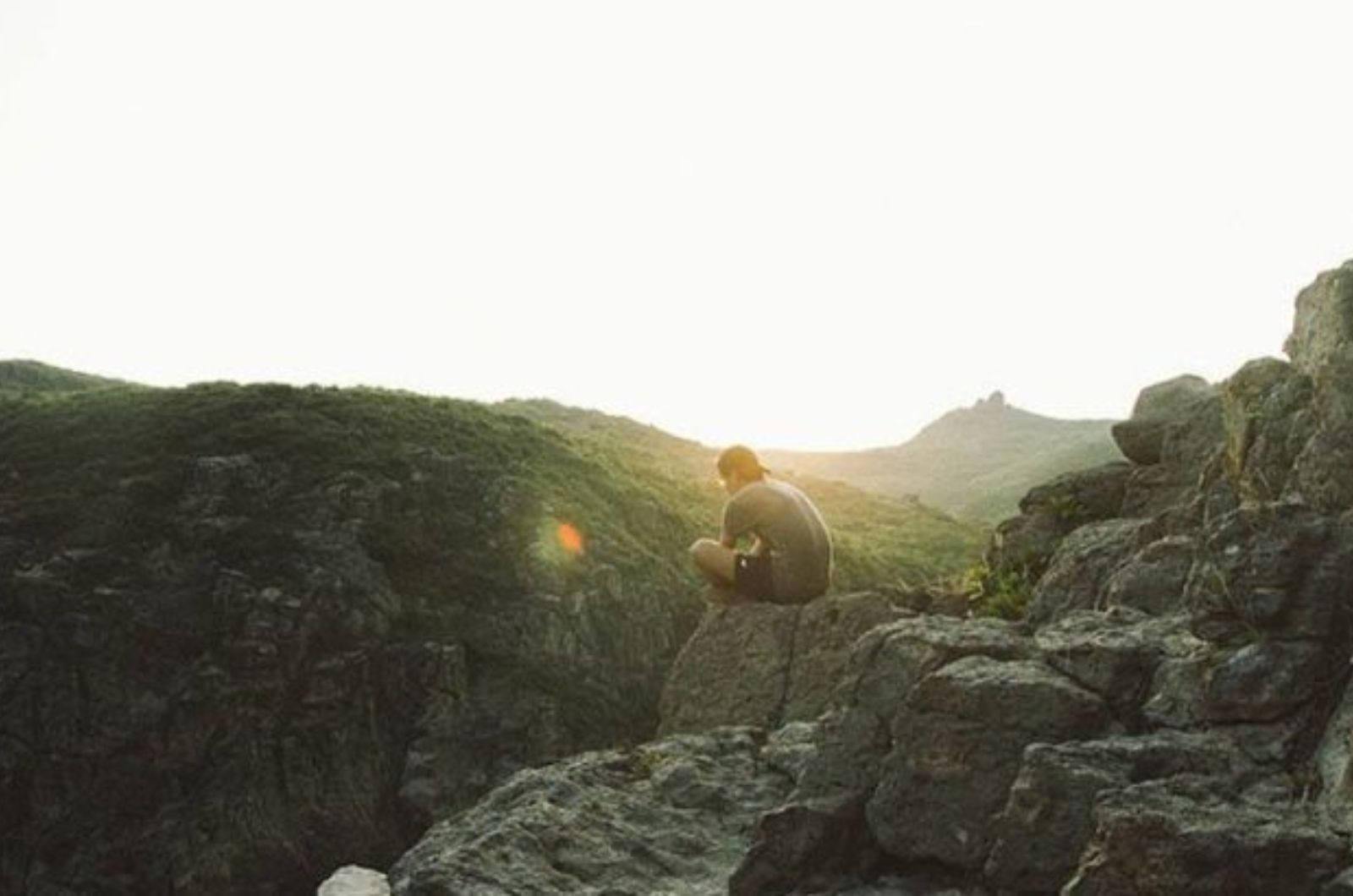 homme assis sur une falaise