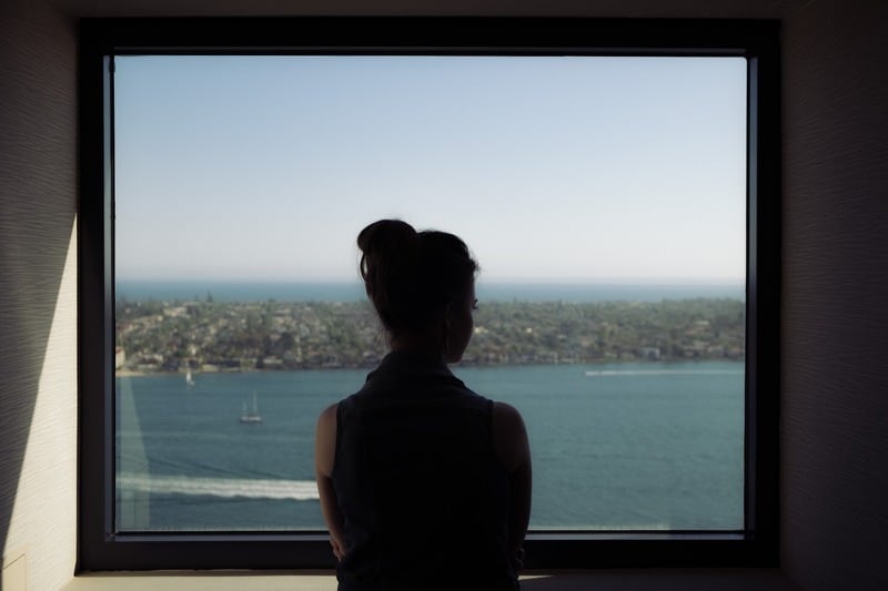 femme regarder dehors océan fenêtre