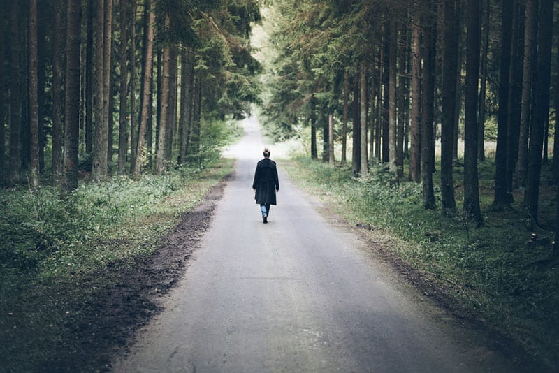 femme solitaire marchant sur la route
