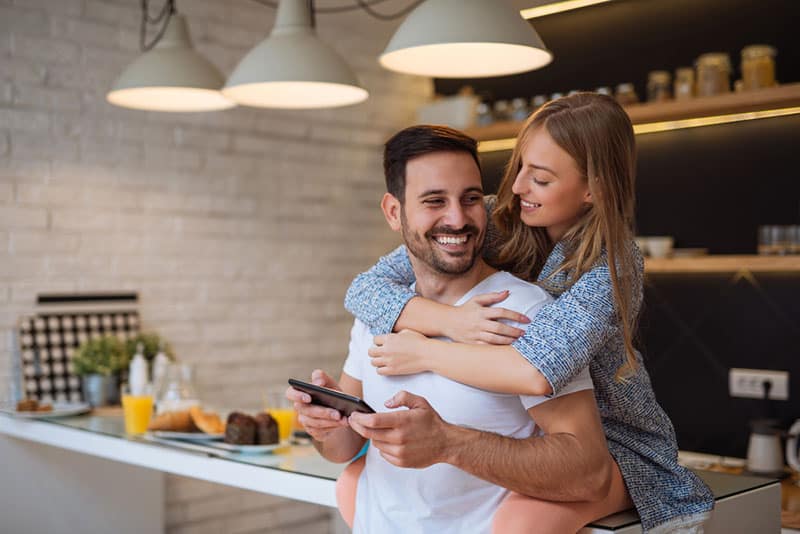 jeune couple, dans cuisine, étreindre