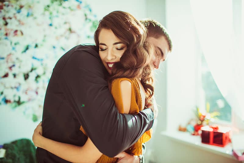 jeune couple, étreindre, dans, salle de séjour