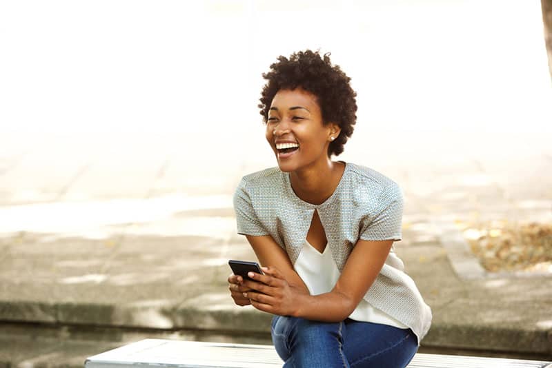 jeune femme afro-américaine avec téléphone à l'extérieur