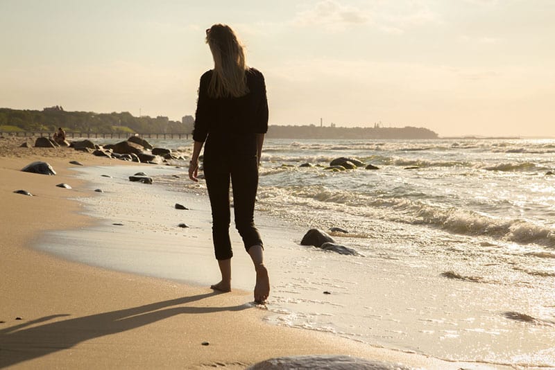 jeune femme marchant sur la plage