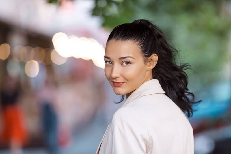 jeune femme regardant en arrière et souriant