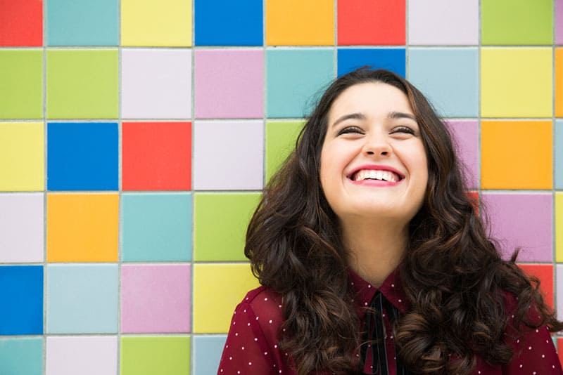jeune femme souriante avec fond coloré