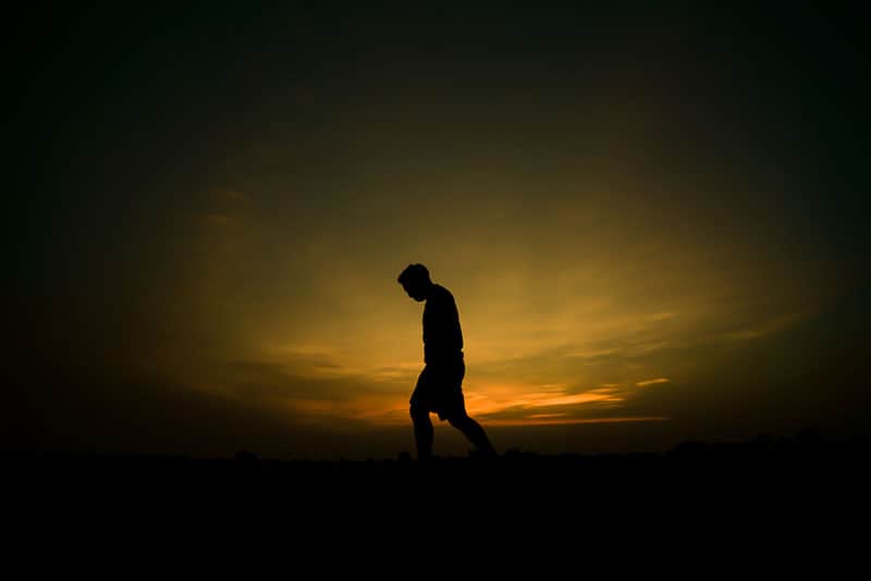silhouette d'un homme triste au coucher du soleil