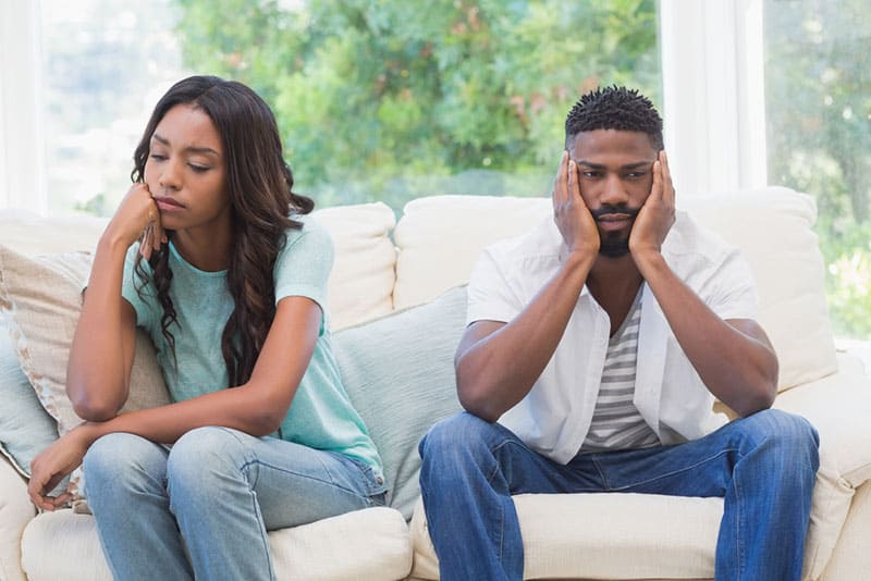 triste couple afro-américain assis sur le canapé