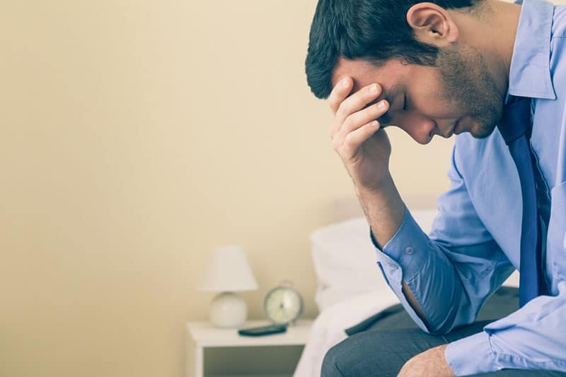 triste homme déprimé assis sur le lit