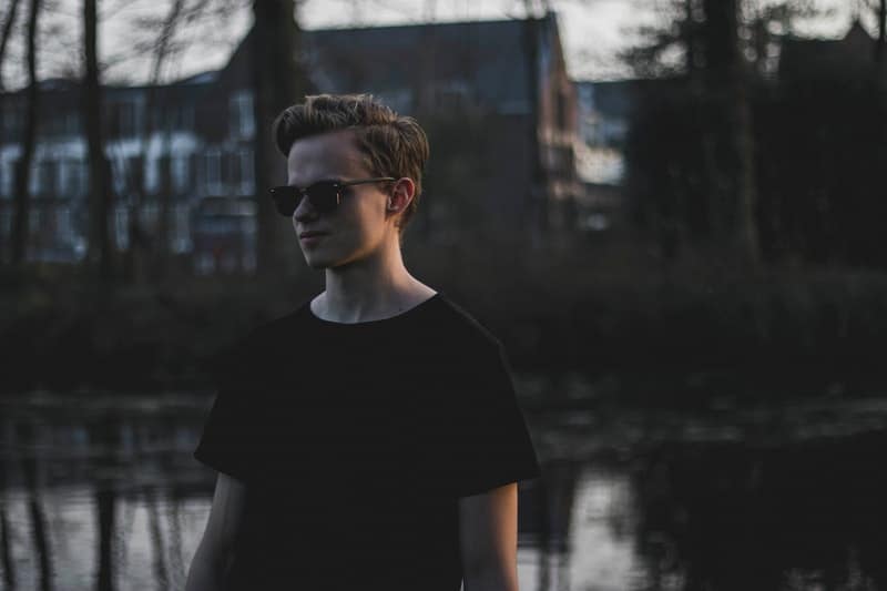 un adolescent au bord de la rivière avec des lunettes