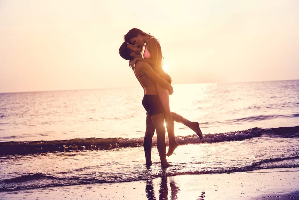 un homme embrasse une femme sur la plage