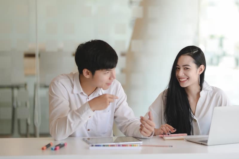 un homme et une femme parlant assis à une table