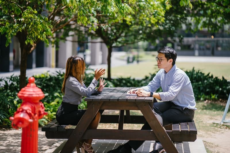 un homme et une femme s'assoient à une table et parlent