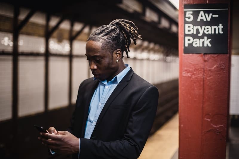 un homme noir tient un téléphone dans sa main