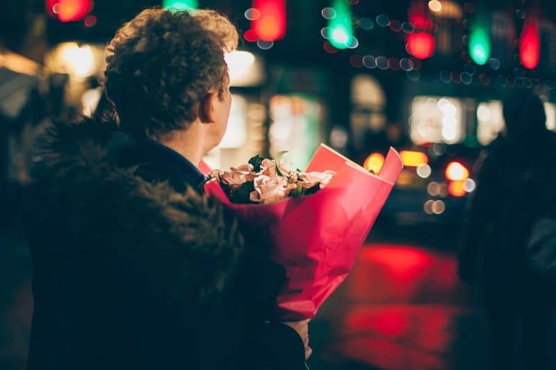 un homme tenant un bouquet de roses