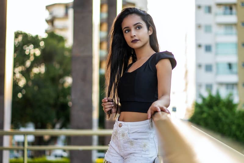 une belle femme appuyée contre une clôture