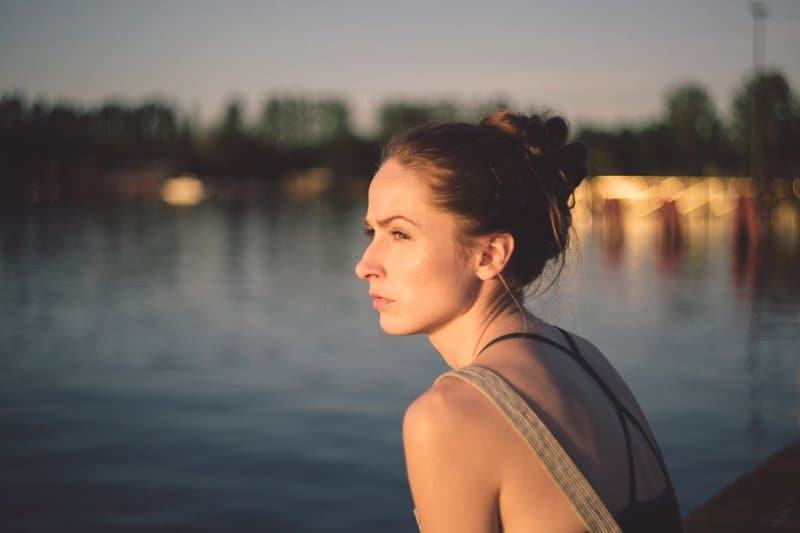 une femme est assise au bord de la rivière