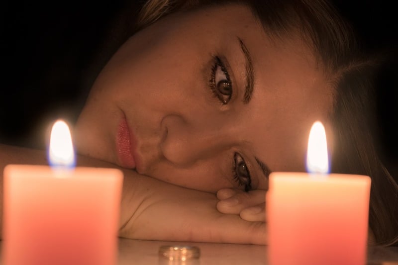 une femme fatiguée regardant des bougies