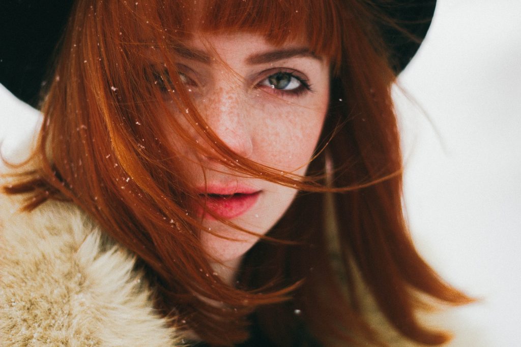 une femme rousse avec un chapeau sur la tête