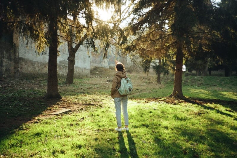 une femme solitaire avec un sac à dos dans les bois