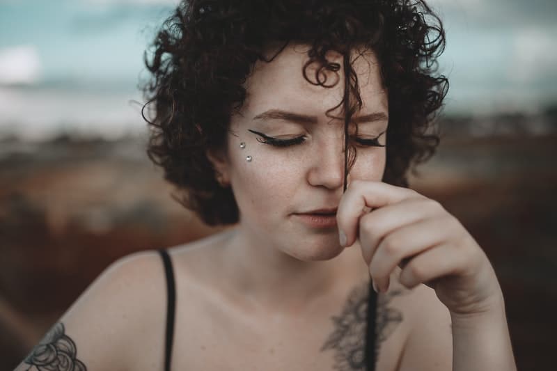 une femme tatouée tenant ses cheveux
