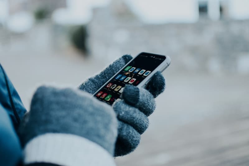 une personne en gants utilise un smartphone