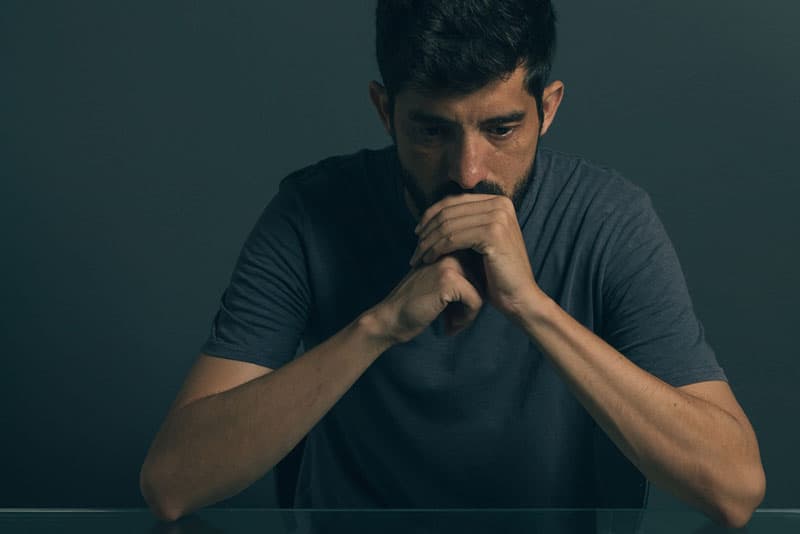 homme triste assis à la table