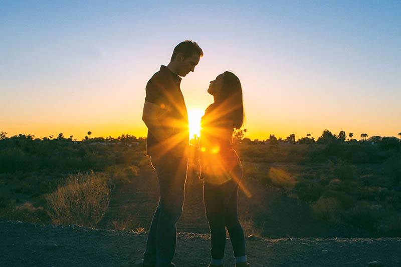 jeune couple, tenant mains, dans, coucher soleil