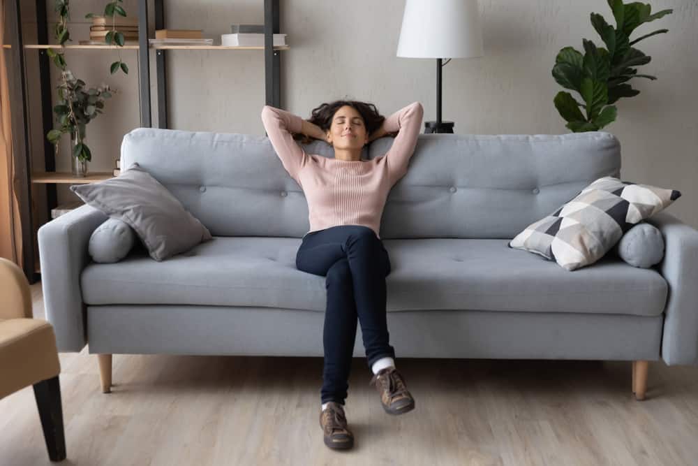 la femme s'assied pensivement sur le canapé