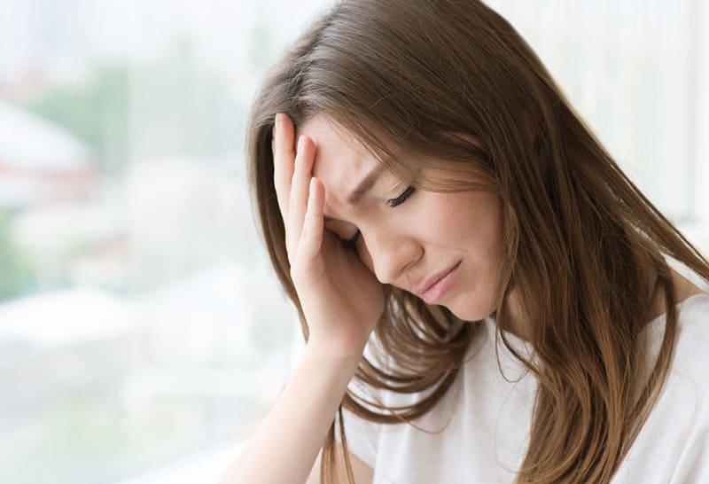 triste jeune femme pleurant par la fenêtre