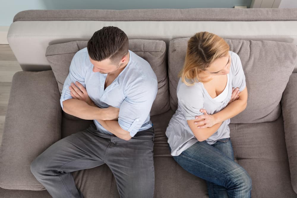 un homme et une femme sont assis en colère face à face