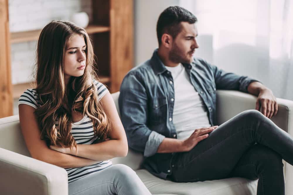 un homme triste et une femme sont assis l'un à côté de l'autre