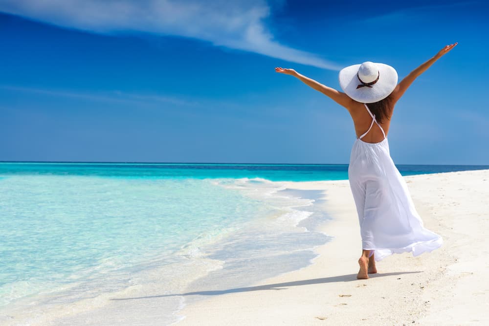 une femme aux bras tendus définit la plage