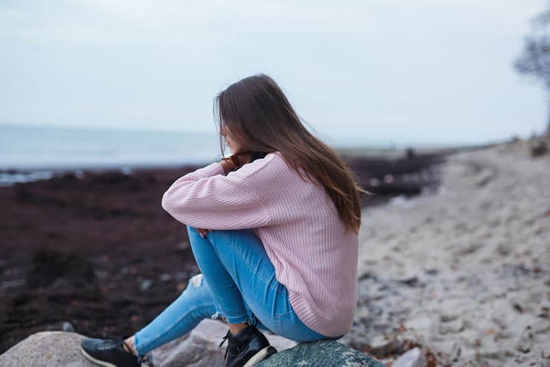 triste jeune femme assise sur les escaliers à l'extérieur