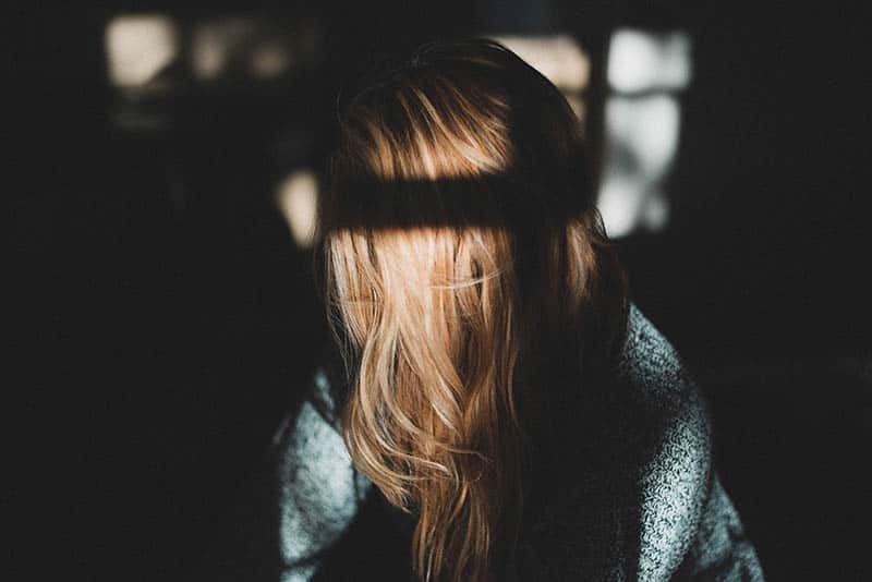 triste jeune femme blonde dans l'obscurité
