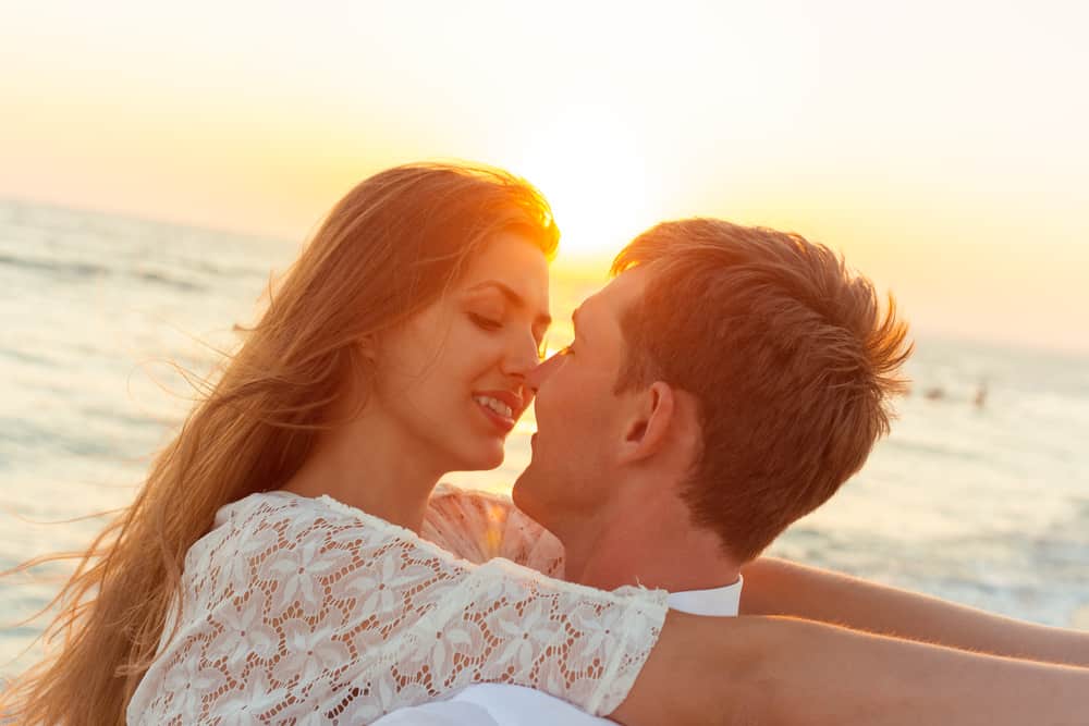 un homme et une femme embrassant au bord de la mer